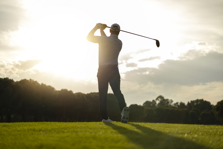 Golfer at sunset on the course